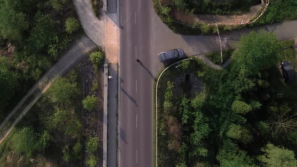 Boy roller skating on the lonely road aerial shot