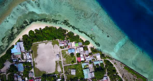 Wide angle overhead tourism shot of a sunshine white sandy paradise beach and blue sea background in