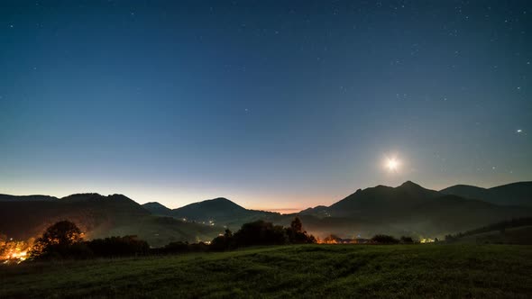 Starry Night Sky with Moon Rising over Mountains in Rural Countryside