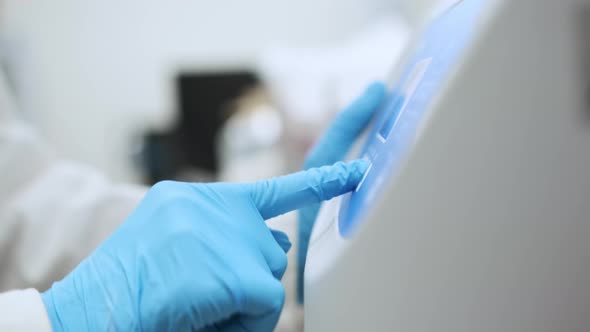 Woman Sets Parameters on the Centrifuge for Sample Preparation