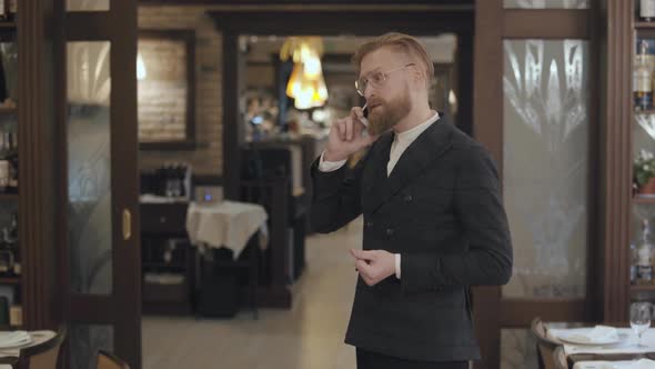 Portrait of a Successful Business Man in Stylish Glasses with a Red Beard Talking