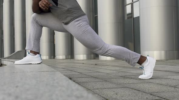 Close-Up of Man Stretching Thighs and Hamstrings to Decrease Chance of Injury