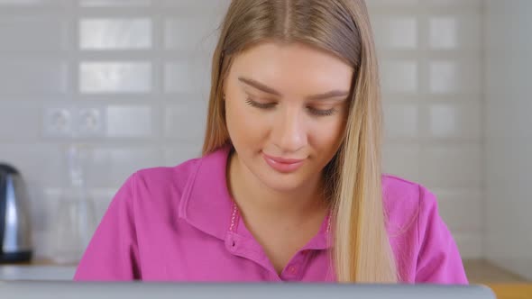 Pretty white female doing distant work on notebook computer at home during lockdown in 4k footage