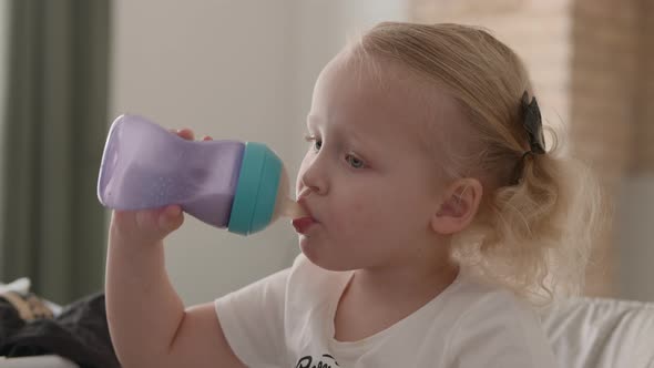 Little child drinking milk from the bottle