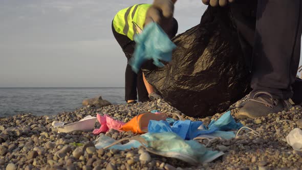 Coronavirus plastic waste, used face mask, gloves in the ocean. Garbage collector or volunteer