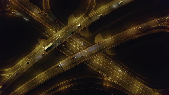 Aerial View of a Multilevel Highway Crossroad with Moving Cars at Sunset