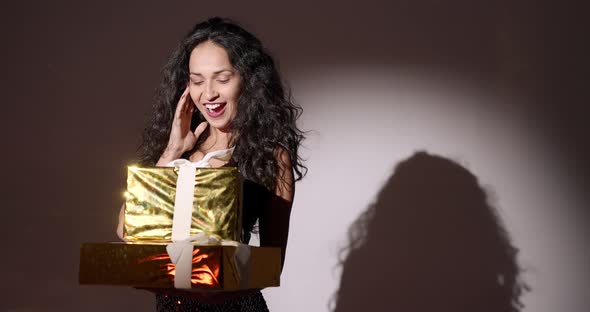 Elegant Hispanic Woman with Present Boxes in a Studio