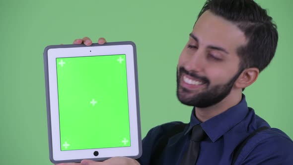 Happy Young Bearded Persian Businessman Showing Digital Tablet