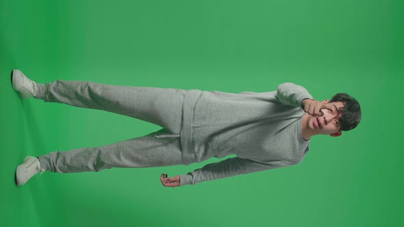 Full Body Of Angry Asian Man Scolding While Standing On Green Screen In The Studio