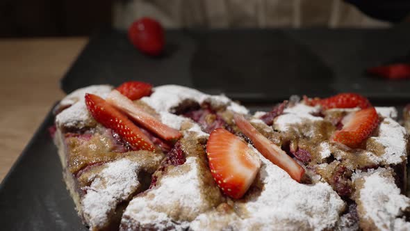 Woman Decorates Fresh Baked Cake with Strawberry Slices