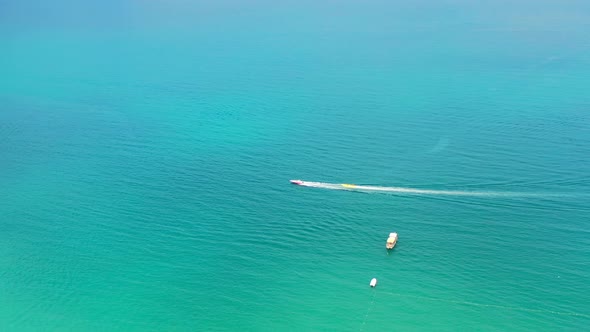 aerial view of a single lonely banana boat being pulled with tourists on the Mediterranean sea of Tu