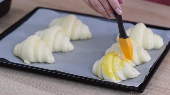 Brushing egg wash on croissant dough for nice color after bake