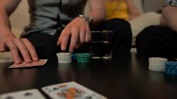 Close Up of Hands with Playing Cards and Chips on Table.