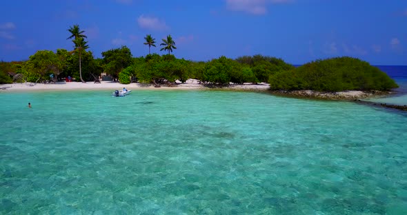 Wide birds eye island view of a white paradise beach and aqua blue water background in colorful 4K