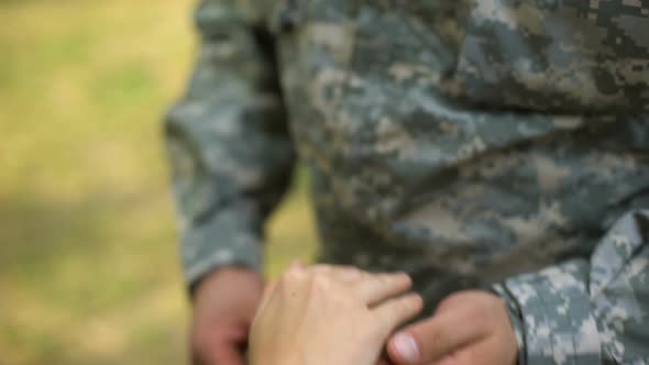 Soldier Putting Wedding Ring on Girlfriends Hand, Romantic Moment, Engagement