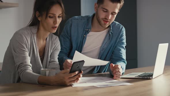 Miserable young caucasian couple having financial problems due to new house.