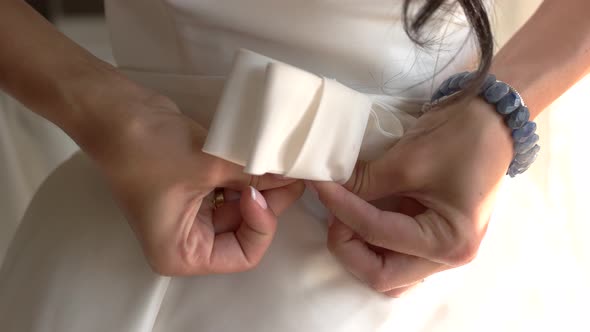 Woman Putting Belt on Dress.