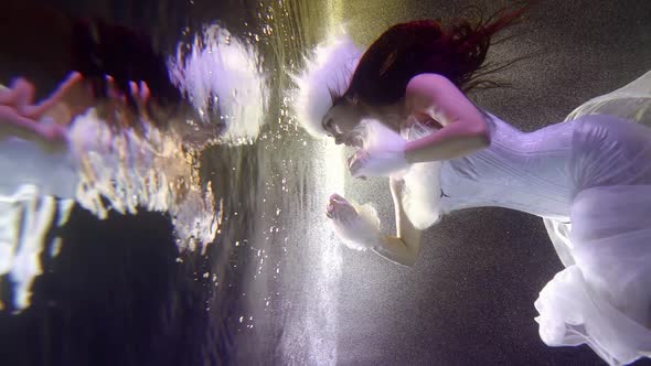 a Beautiful Brunette with Long Hair Hovered in Front of the Vertical Surface of the Water Dividing