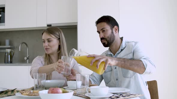 Family Couple Sitting at Dining Table with Dish