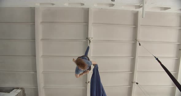 Training Aerial Silks Tricks in the Gym Woman Hanging in the Air on Fabric