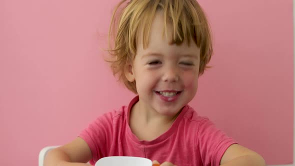 Happy Child Drinks Milk From a Cup