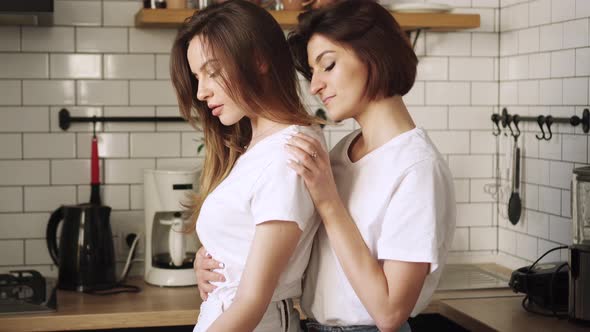 A Young Couple of Lesbians Gently Cuddle at Home.