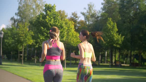 Beautiful Female Runners Jogging in Summer Park