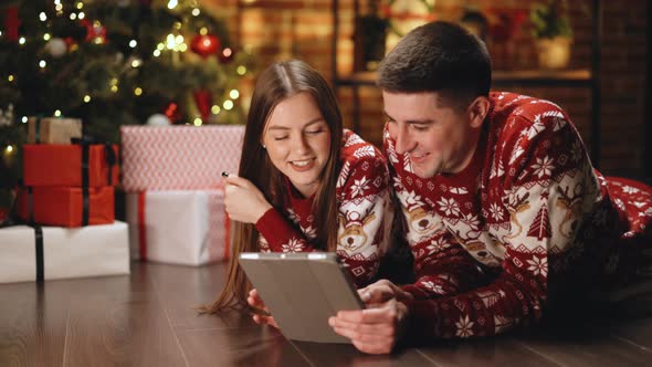 Couple in Love With Beautiful Decorated Living Room Using Tablet Online Shopping
