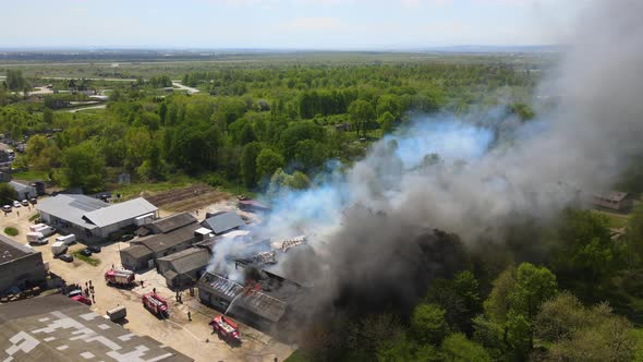 Aerial View of Firefighters Extinguishing Ruined Building on Fire with Collapsed Roof and Rising