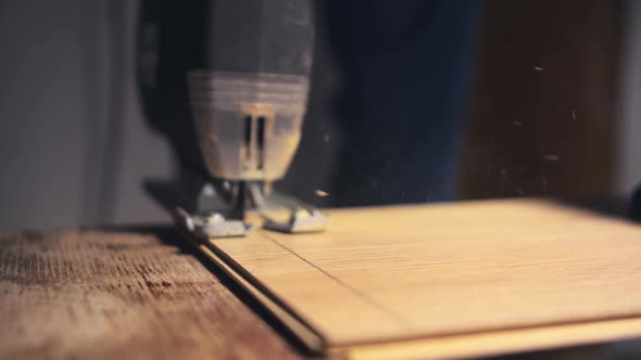 Electric Jigsaw in Action Close Up. Man Cutting Laminate Board. Manufacturing of Furniture