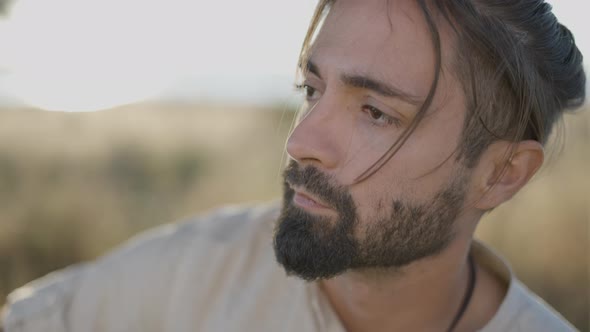 Sad Face Closeup of Bearded Spanish Man Looking Aside While Playing Guitar Outdoors  Slowmotion