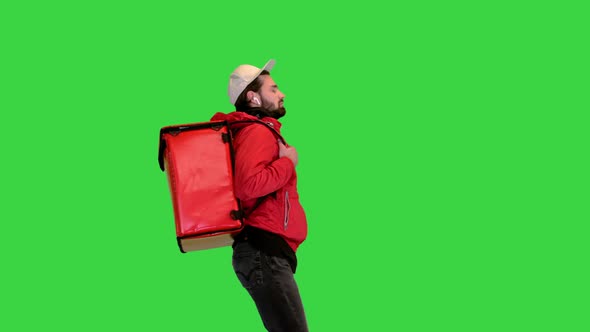 Courier Walking with a Heavy Thermo Backpack on a Green Screen Chroma Key