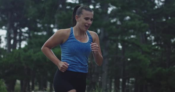 Slow Motion Tracking Shot of a Young Woman in Sportswear Jogging Through an Evergreen Forest on a