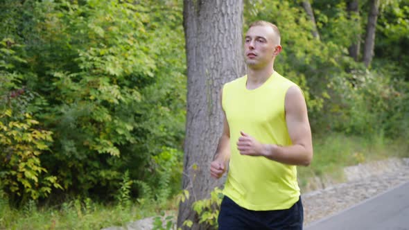 Man in Yellow Top Running By the Forest