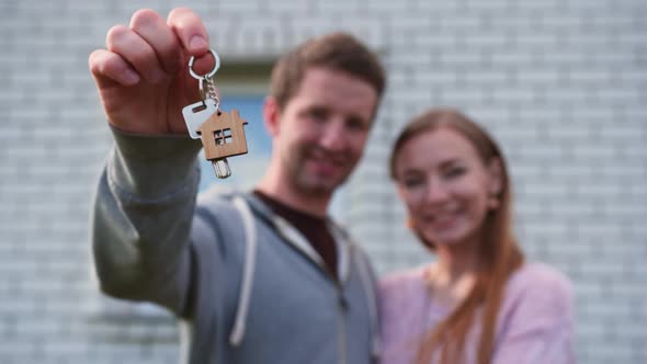 Young Spouses with Keys To a New Home. The Concept of Buying a New Home