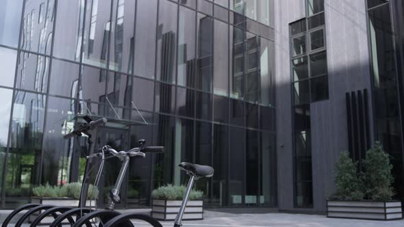 Shared Vehicles Standing on Parking Lot at Modern Glass Office Building Morning