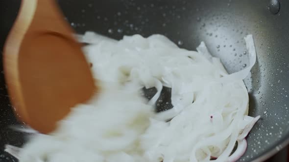 White Asian noodle being cooked and stir fried in the pan preparing to make Pad-Thai