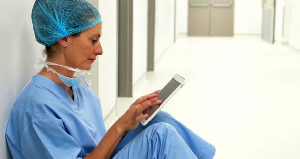 Surgeon sitting on floor and using digital tablet