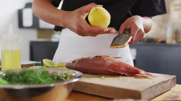 Caucasian female chef preparing a dish and smiling in a kitchen