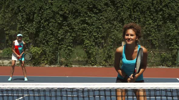 Two Girls Playing Tennis in the Pair