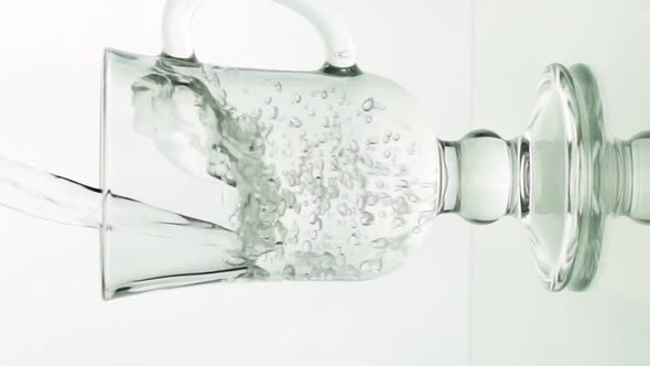 Vertical Video Crystal Clear Water Pouring Into Glass Mug for Latte