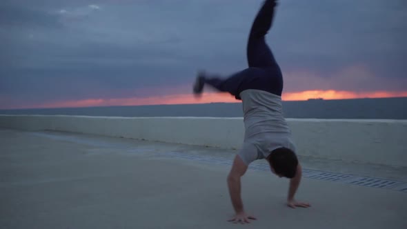 Young Caucasian Male Gymnast in Casual Outfit Perfoming Serie of Acrobatic Exercises in Slowmotion