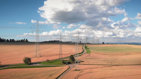 Transmission power line towers on wheat field. 