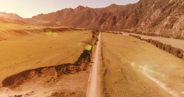 Aerial Rural Mountain Road and Meadow at Sunny Summer Morning. Asphalt Highway and River.