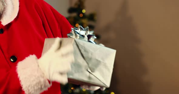 Santa claus checking a gift box and smiling
