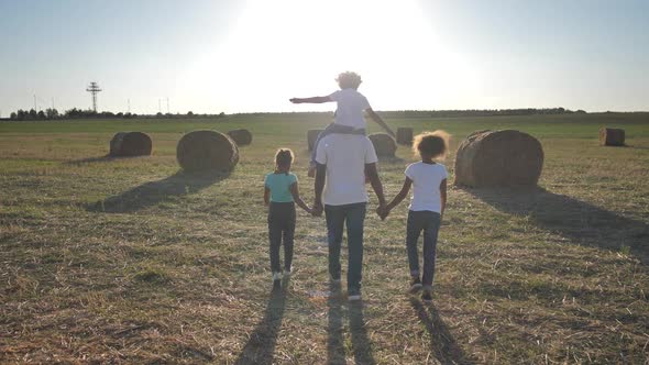 African American Family Walking Across Wheat Field