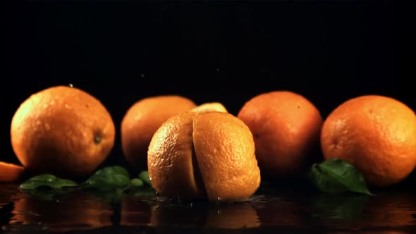 A Fresh Orange Falls on the Table and Splits Into Two Halves