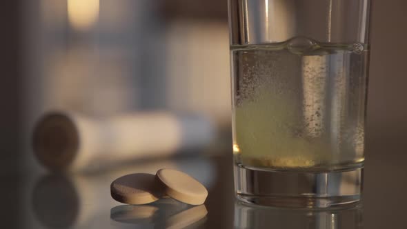 Effervescent tablet dissolves in glass of water. Health care, pharmacy concept