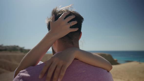 Love and Feelings of Young Couple Man and Woman are Hugging and Kissing Against Sea