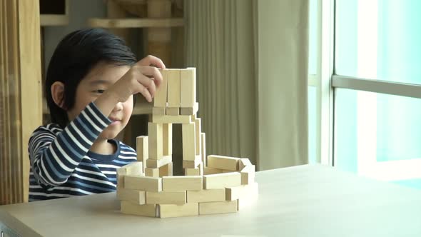 Cute Asian Child Playing Wooden Bolck In The Living Room
